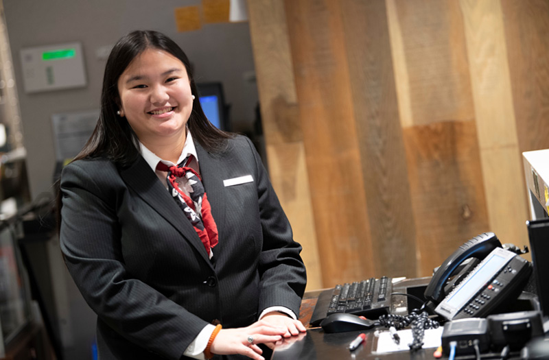 Young woman smiling wearing business casual in a business setting